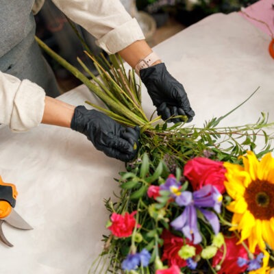 Female decorator creating beautiful bouquet at table. Lifestyle flower shop